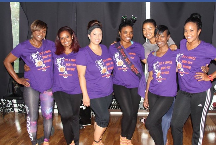 A group of friends wears matching custom t-shirts that say "Ghouls Night Out, Witches!" at a Halloween-themed bachelorette party. 