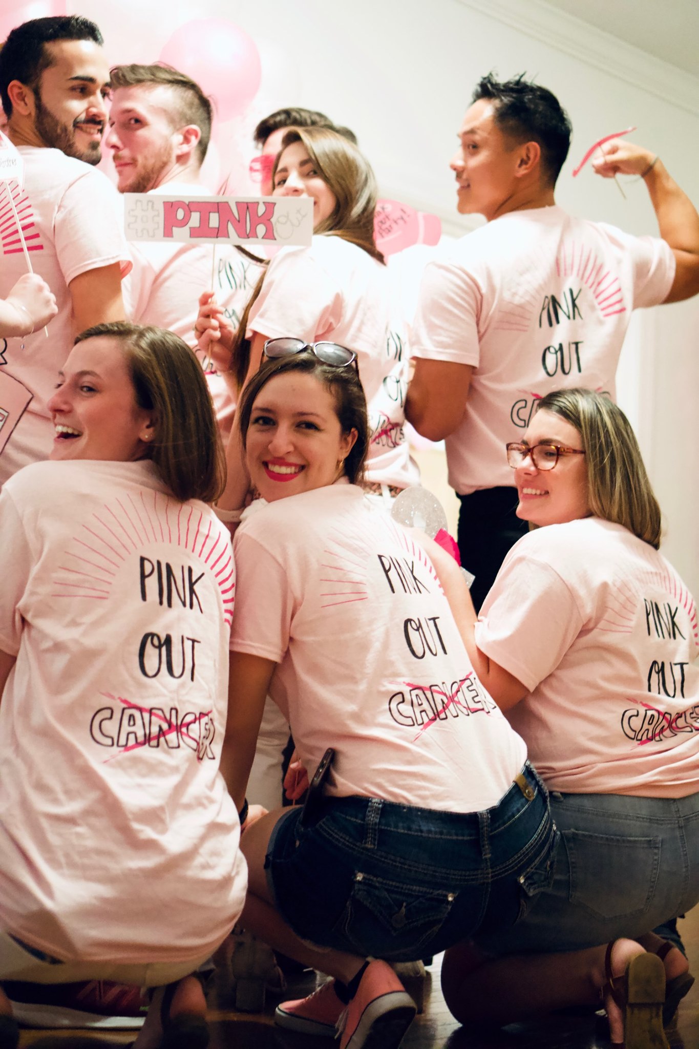 A group wearing pink matching custom t-shirts that say, "Pink Out Cancer." 