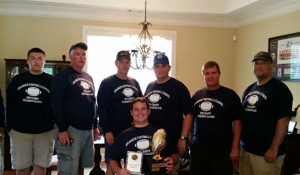 A group of friends wear their matching custom fantasy football t-shirts.