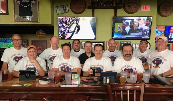 A group of friends wear their matching custom fantasy football t-shirts. 