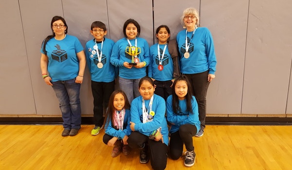 A robotics team poses in their custom long-sleeve t-shirts.