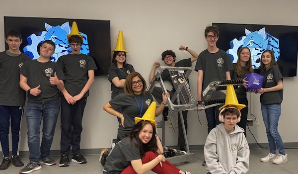 A robotics team poses in their custom t-shirts. 