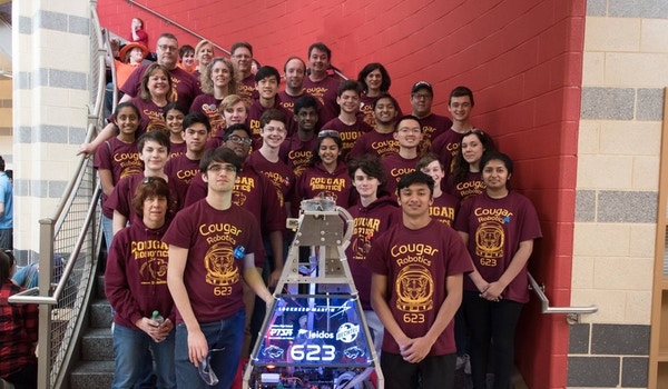 A robotics team poses in their custom t-shirts. 