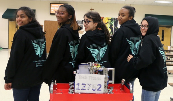 A robotics team wears their custom hoodies. 