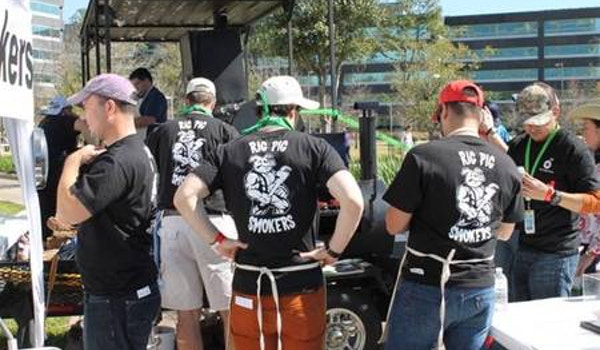 A cookoff team wears matching custom t-shirts that read, "Rig Pig Smokers." 