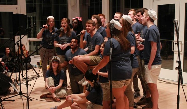 A college a cappella group performs while wearing matching custom t-shirts. 