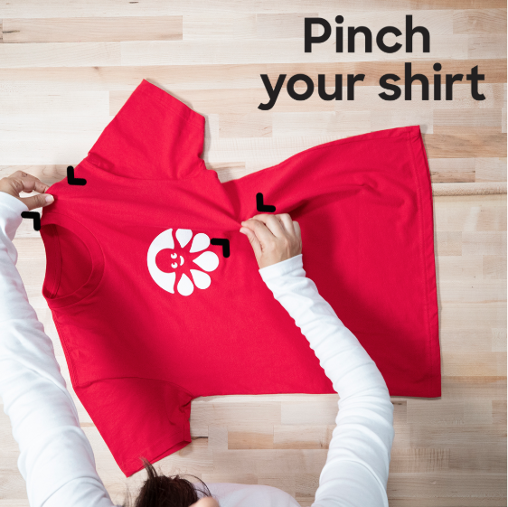 Pinch a shirt to begin folding it.