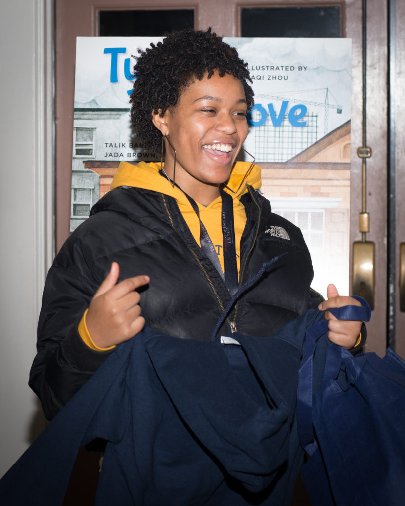 Young woman junior staff member holding her custom hoodie