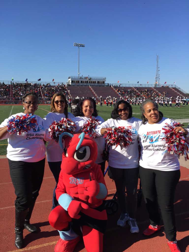 Alumni Cheerleaders posing at a homecoming game