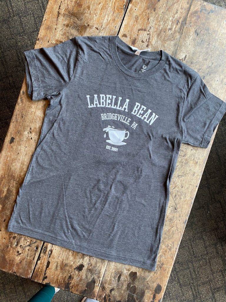 Image of the custom LaBella Bean t-shirt laying flat against a wood surface