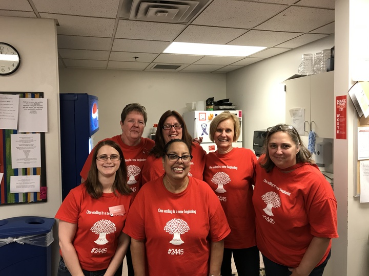 A team of process improvement professionals shows off their custom t-shirts.