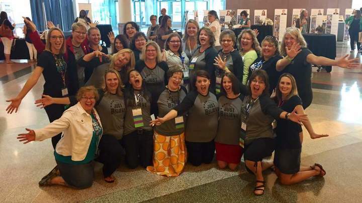 A team poses together in their custom t-shirts at a conference.