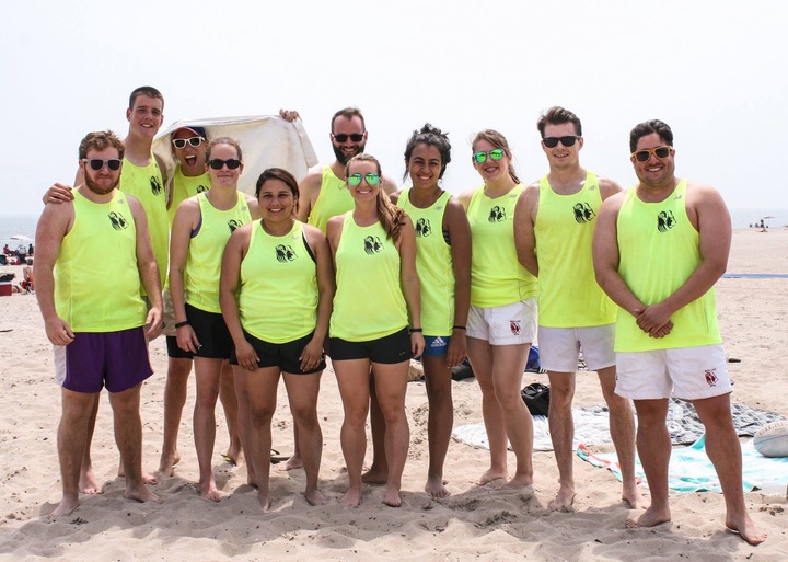 A beach rugby team in matching yellow custom tank tops