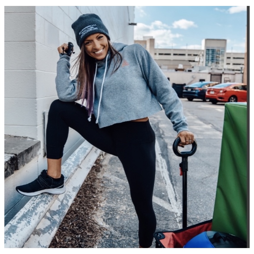Woman wearing a beanie and holding onto a wagon
