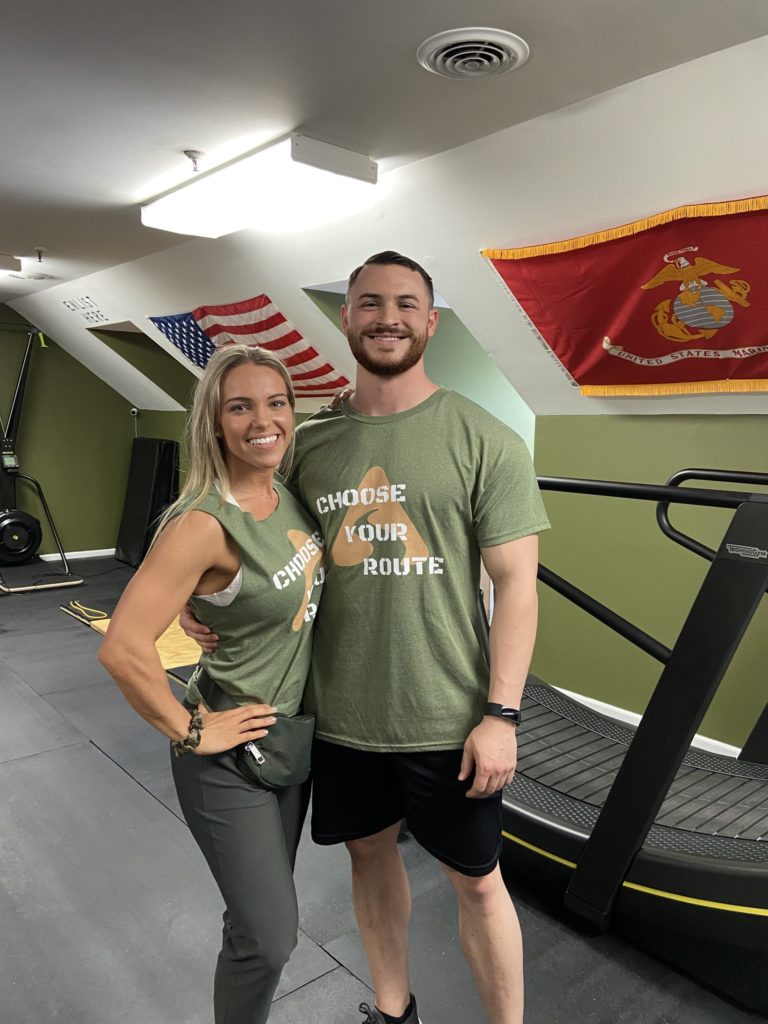 Two fit young people standing in front of gym equipment