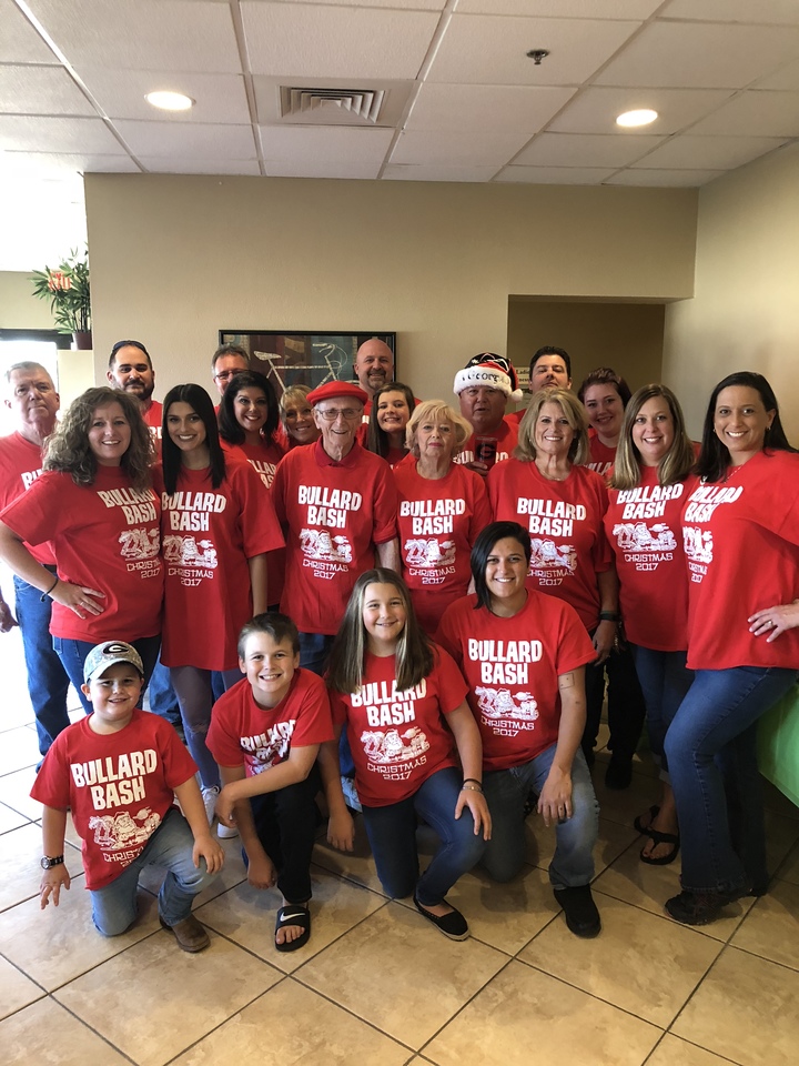 A group of friends and family gather wearing their matching custom Christmas t-shirts.